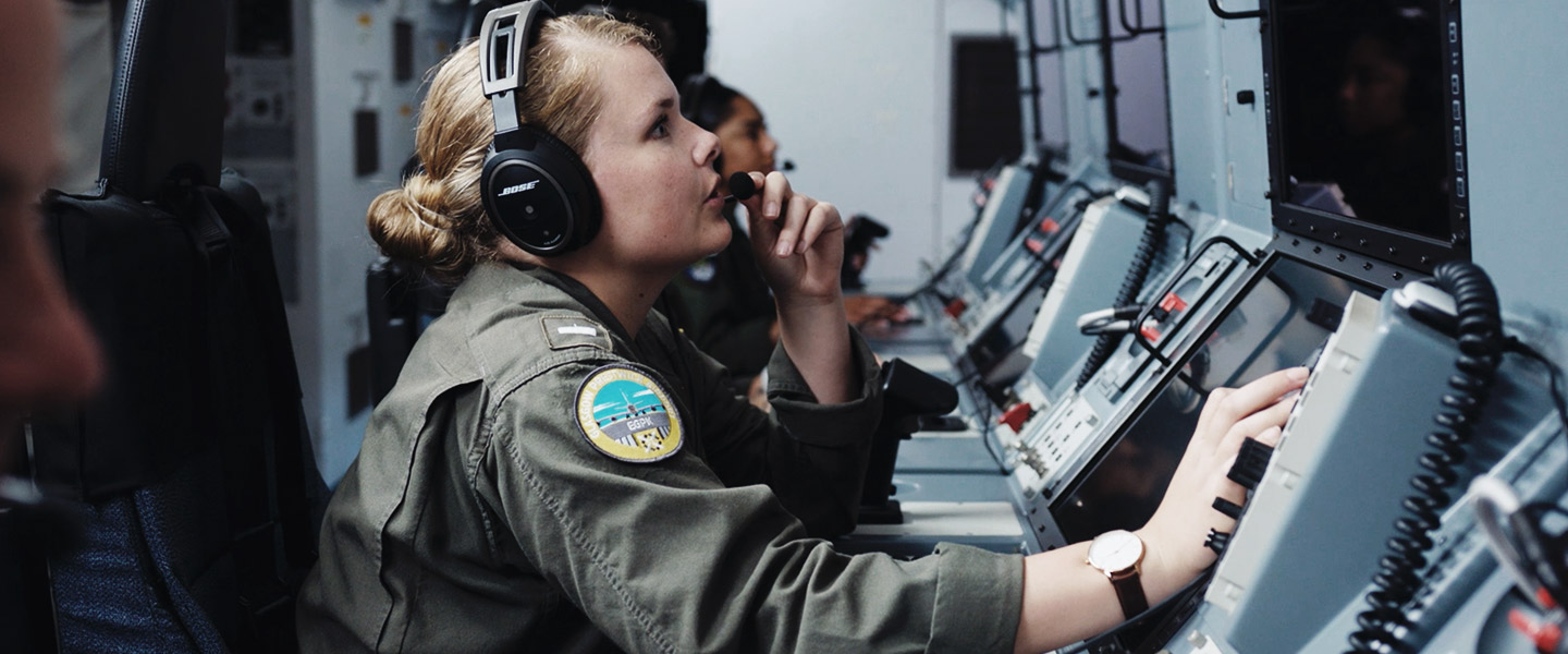 A United States Naval Flight Officer runs through the on-station checklist aboard a P-8 Poseidon.