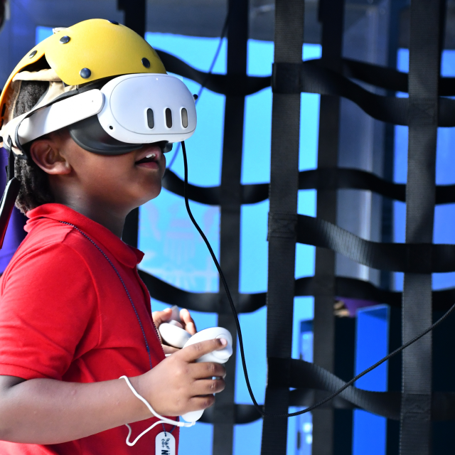 Child wears VR headset at The Strike Group experience, presented by America's Navy.