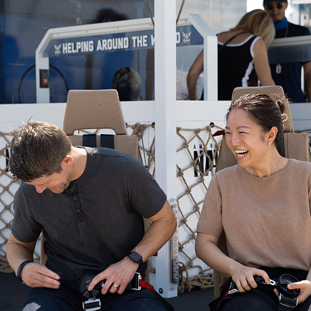 Navy Strike Group participants pose for photo at the Support Cube while learning about Navy humanitarian efforts during The Strike Group experience, presented by America's navy.